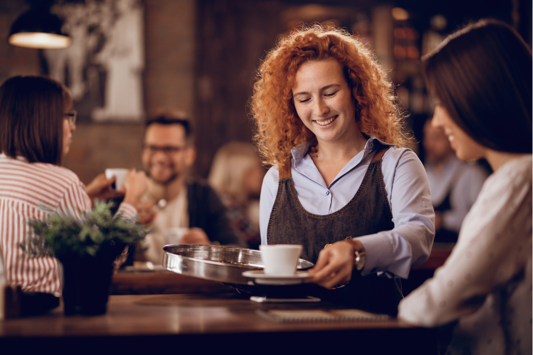 young-happy-waitress-giving-coffee-female-guest-while-working-bar.jpg